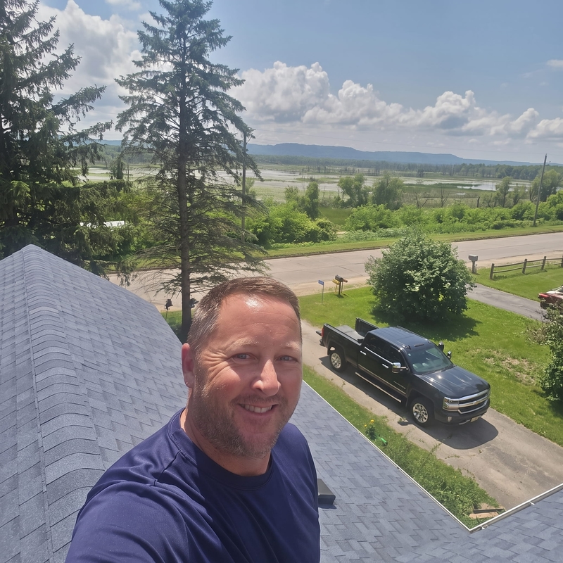 Chad Wegscheider, owner of Casa Builders, on a completed roof overlooking the river valley